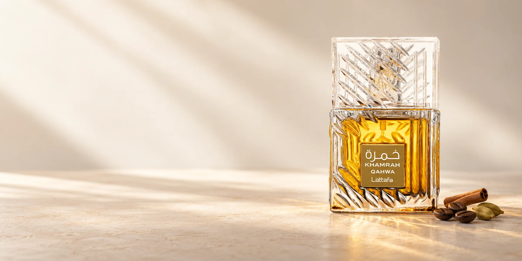Khamrah Qahwa in cut glass with golden liquid, coffee beans, cinnamon and cardamom on warm ivory stone. Concept image.